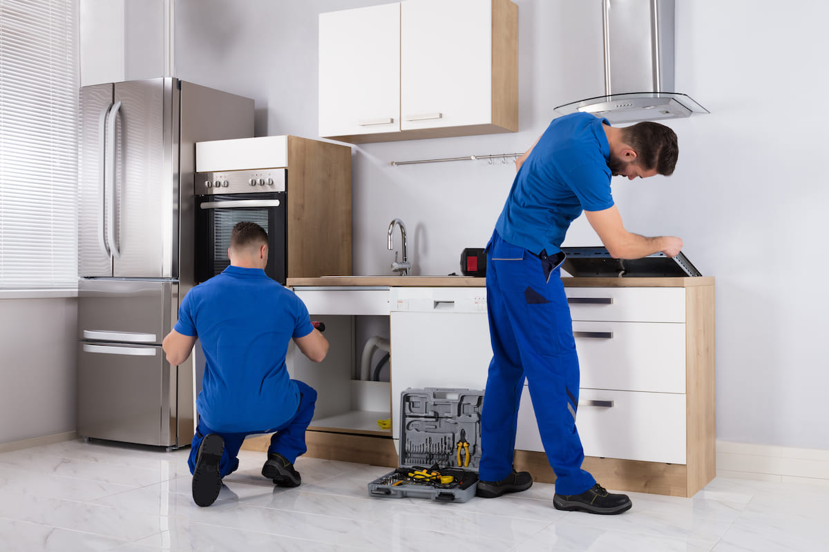 technicians install the appliances in the kitchen